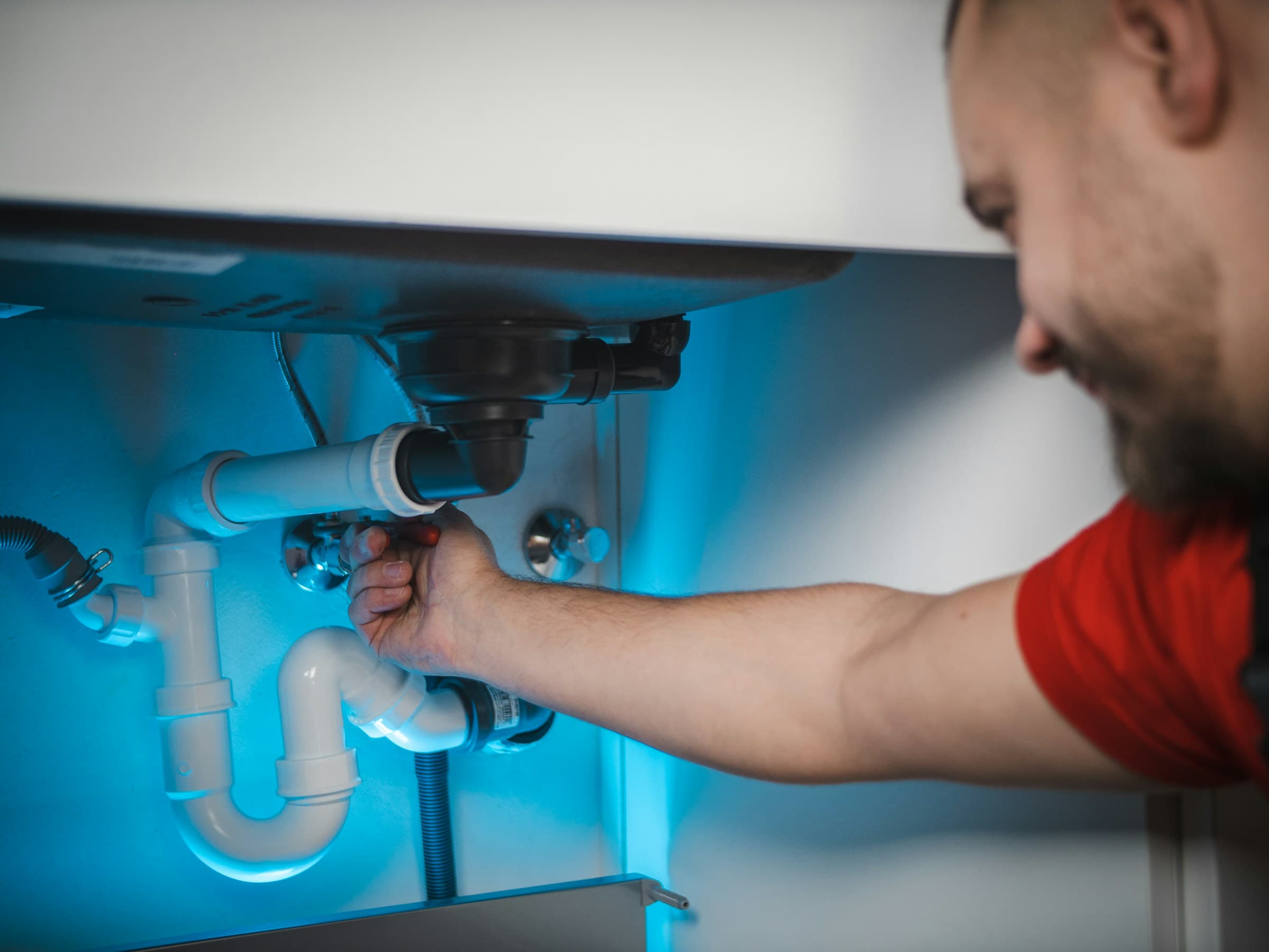 Plumber working on a pipe install, representing the everyday trades Nexa supports